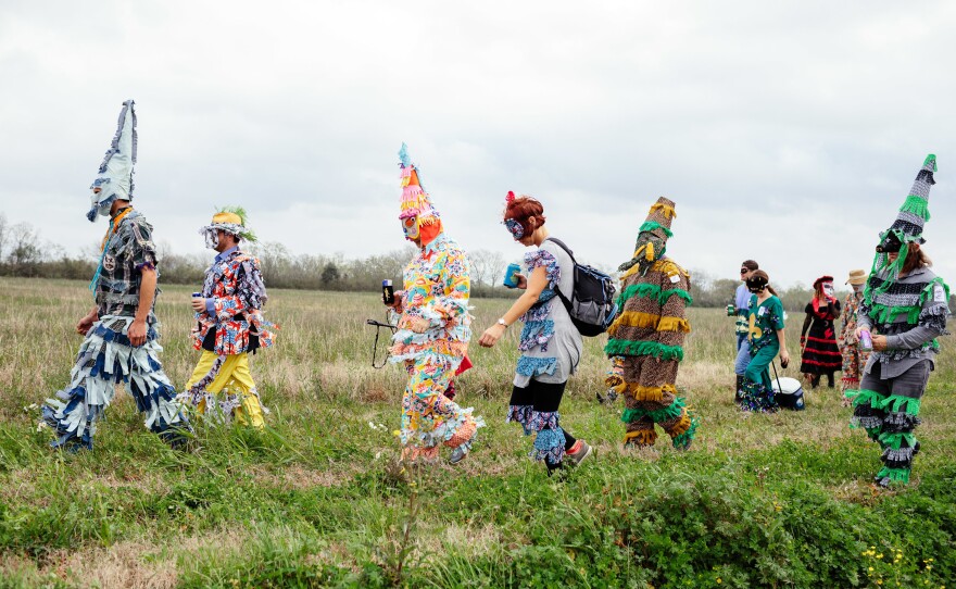 Mardi Gras revelers walk to the next house for another round of the chicken chase and to beg for other supplies such as beer, boudin, and rice and beans.