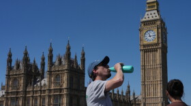 A man drinks Tuesday outside the Palace of Westminster in London.