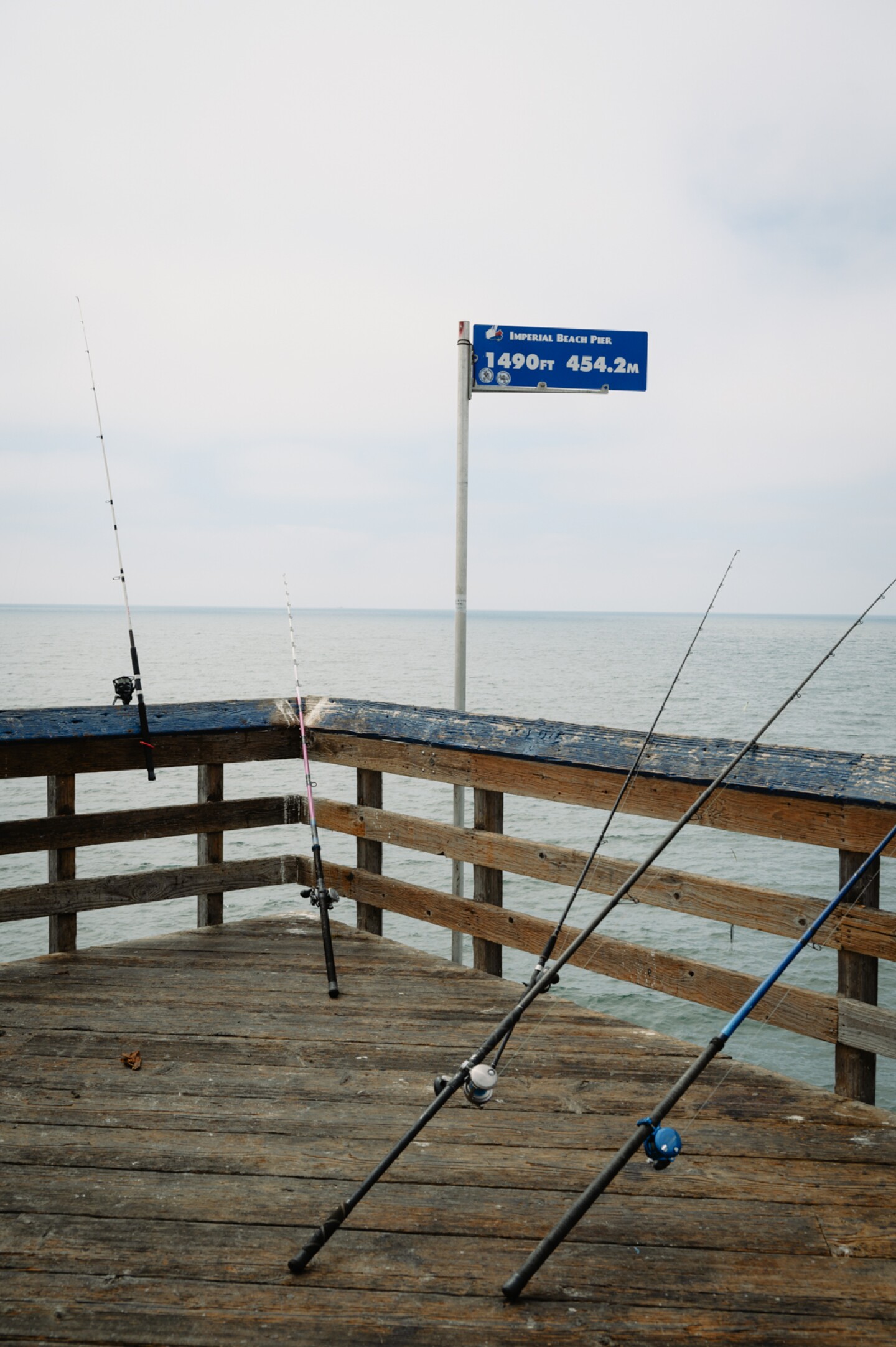 Fishing poles crowd the railing outside Tin Fish restaurant at the end of the IB Pier in Imperial Beach, Calif. on Sept. 3, 2024.