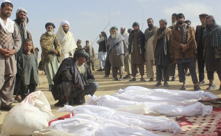 Afghan villagers gather around several victims' bodies who were killed in the November battle in Kunduz province, Afghanistan.