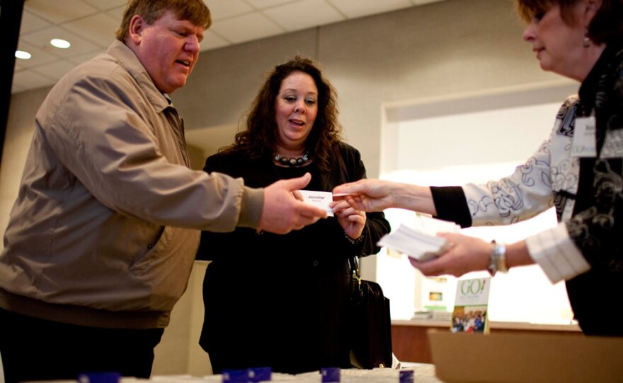 Roni Chambers, executive director of Go! Network (right), checks in Jennifer Barfield, 47, and her husband, Brian Barfield, 53, at a job networking meeting in downtown St. Louis.