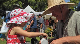 A young participant learns about gardening with Michael Gerdes, director of photography for A GROWING PASSION, at Earth Fair 2013.