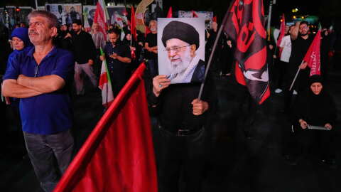 A man holds a poster of the late Iranian Supreme Leader Ayatollah Ali Khamenei in a gathering commemorating him at a square in Tehran, Saturday, July 11, 2026.