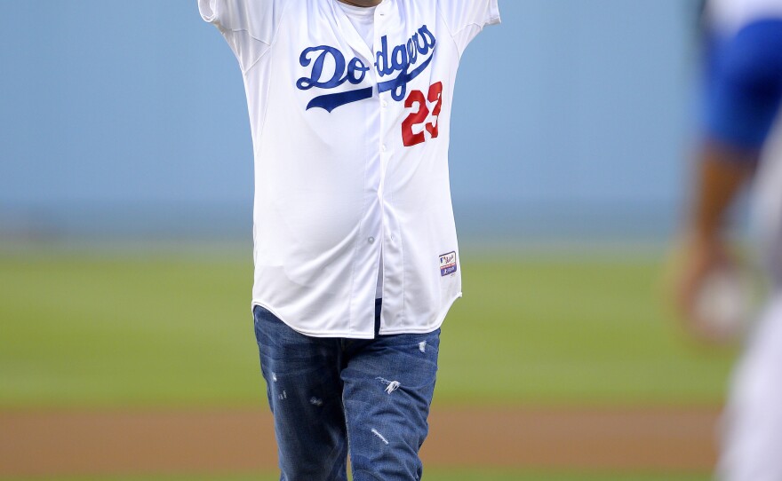 Comedian George Lopez leaves the mound after throwing out the ceremonial first pitch prior to the Los Angeles Dodgers' baseball game against the New York Mets on Wednesday.