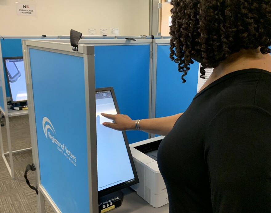 A woman uses a touchscreen ballot marking devices at the San Diego County Registrar of Voters in this undated photo.<br/>