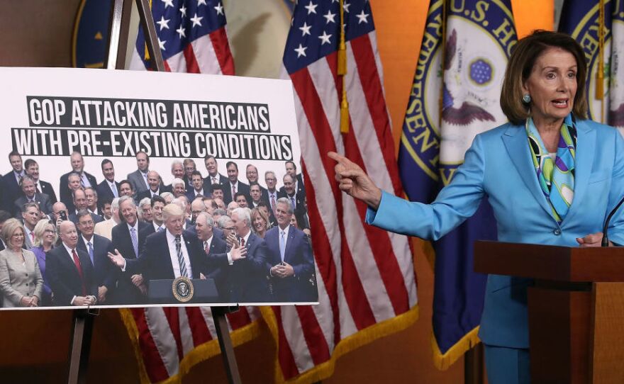 Democratic Minority Leader Nancy Pelosi, D-Calif., speaks about health care as she points to a picture of President Trump with House GOP members during her weekly news conference on Capitol Hill in June.