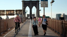 Americans walk less than the citizens of any other industrialized nation, says Tom Vanderbilt. In this file photo from last summer, pedestrians and a cyclist cross the Brooklyn Bridge in New York City.