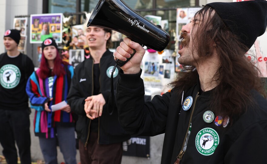 Striking Starbucks worker Kyle Trainer uses a megaphone outside of a Starbucks coffee shop during a national strike on November 17, 2022 in San Francisco, California.