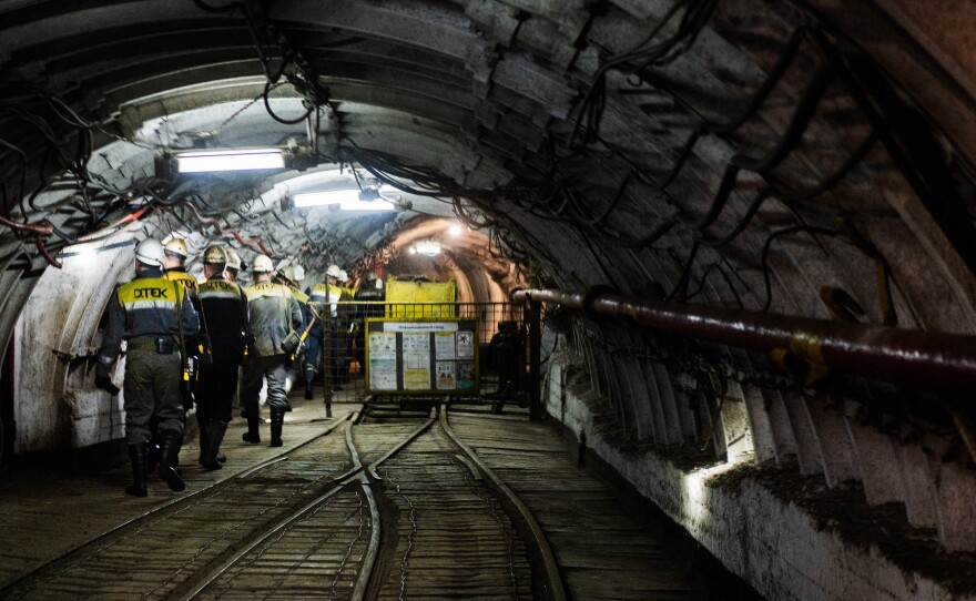 Workers having just gotten off the elevator head deeper into the mine to start their shifts.