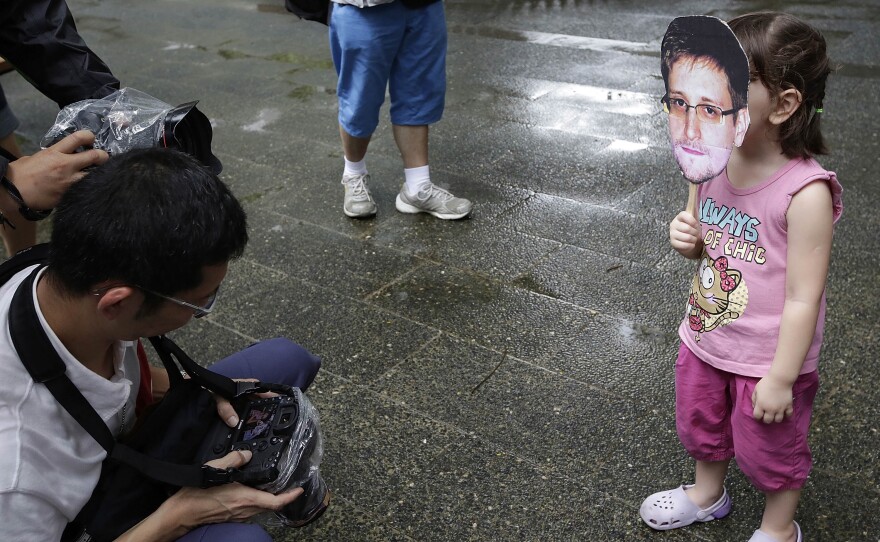 A young girl holds up a cutout image of Edward Snowden's face at the start of a rally in support of the NSA leaker over the weekend in Hong Kong.