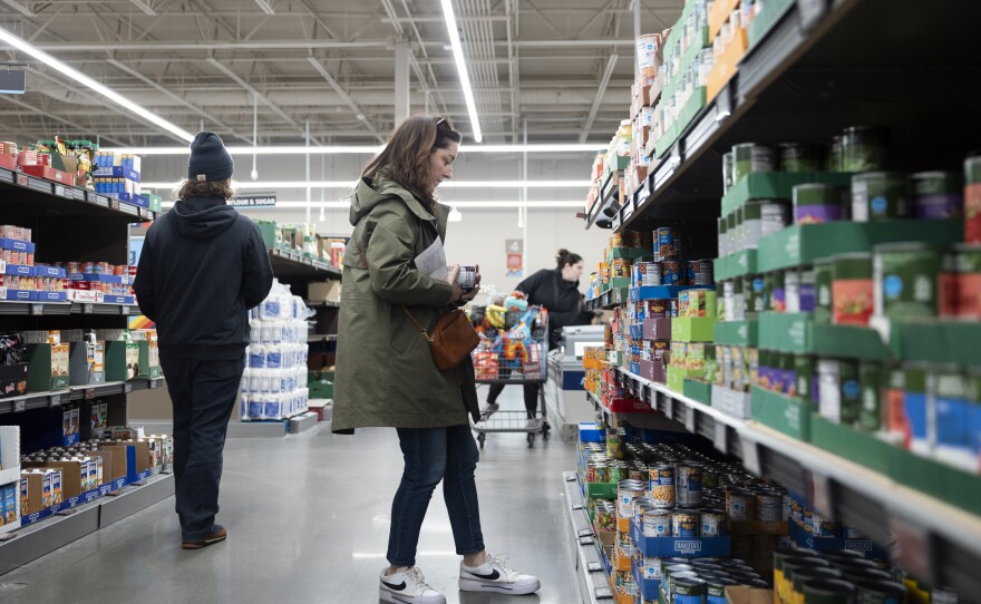 Negro-Henderson looks over canned goods while grocery shopping.