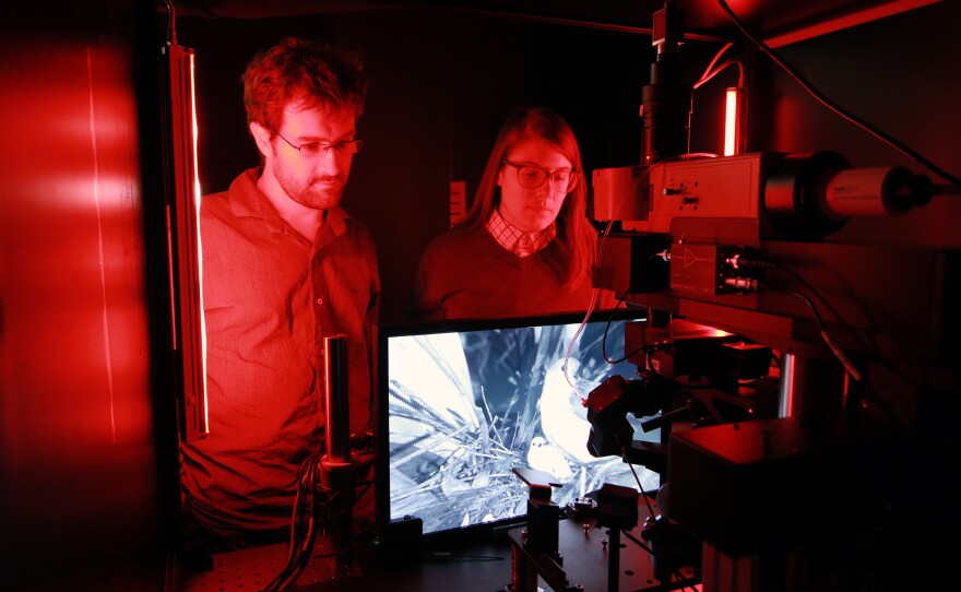 Senior scientist Jerome Lecoq and research associate Kate Roll of the Allen Institute inspect one of the microscopes used to record cellular activity in the visual cortex of mice as they watch movies.