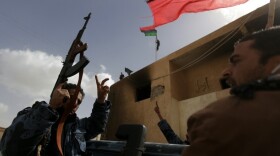 Members of Libya's anti-Gadhafi internal security forces waved their old national flag as they paraded in the eastern city of Tobruk today (Feb 24, 2011).