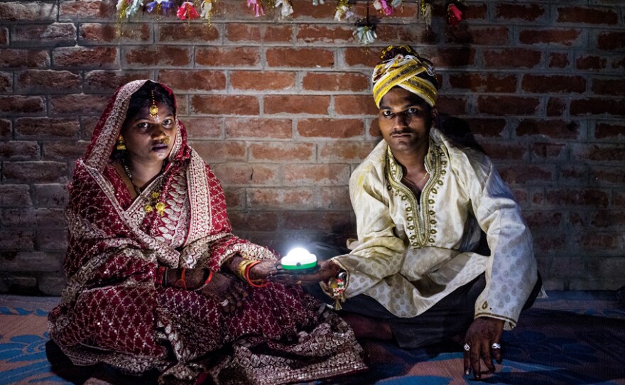 Holding a solar-powered lamp, Soni Suresh, 20, and Suresh Kashyap, 22, celebrate their marriage ceremony in Uttar Pradesh, where 20 million households lack electricity.