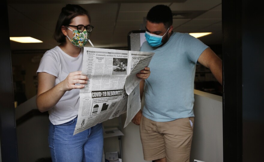 Student journalists Anna Pogarcic and Brandon Standley of UNC's <em>Daily Tar Heel</em> review a recent issue at their offices off campus.