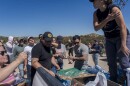 The mutual aid group Border Kindness gives out food, water and clothes to the migrants forced to wait in the desert near Jacumba in the far East San Diego County, Sept. 19, 2023.
