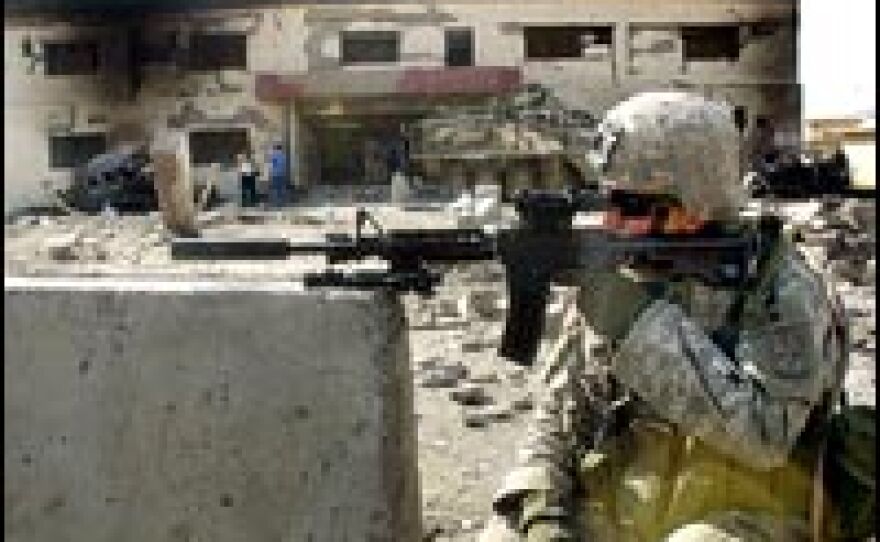 A U.S. soldier secures the area where a suicide car bomb exploded near a police station in Mosul, July 5, 2006.