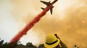 An air tanker drops retardant while battling a wildfire near Mariposa, Calif., Wednesday, July 19, 2017.