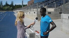 Guor Marial speaks with KNAU'S Janice Baker at the Northern Arizona University track in Flagstaff, Ariz.