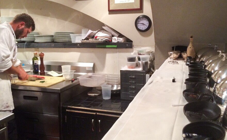 David Uzzell at work in the kitchen at Marcel's. Uzzell has a written list of daily tasks from chef and owner Robert Wiedmaier at his station, and his ever-present notepad and pencil on the shelf above serves as communication tools for more specific instructions.