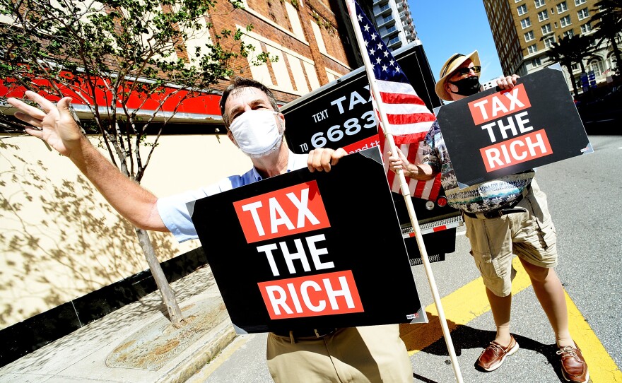 Two protesters from progressive group MoveON calling for higher taxes for the rich and corporations in Tampa, Fl., on May 17. Polls typically show support for increasing taxes for the wealthy.