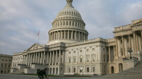 A biker rides past the U.S. Capitol on Monday. Lawmakers are negotiating over plans to raise the federal debt ceiling amid warnings that the government soon won't be able to pay its debts in full.