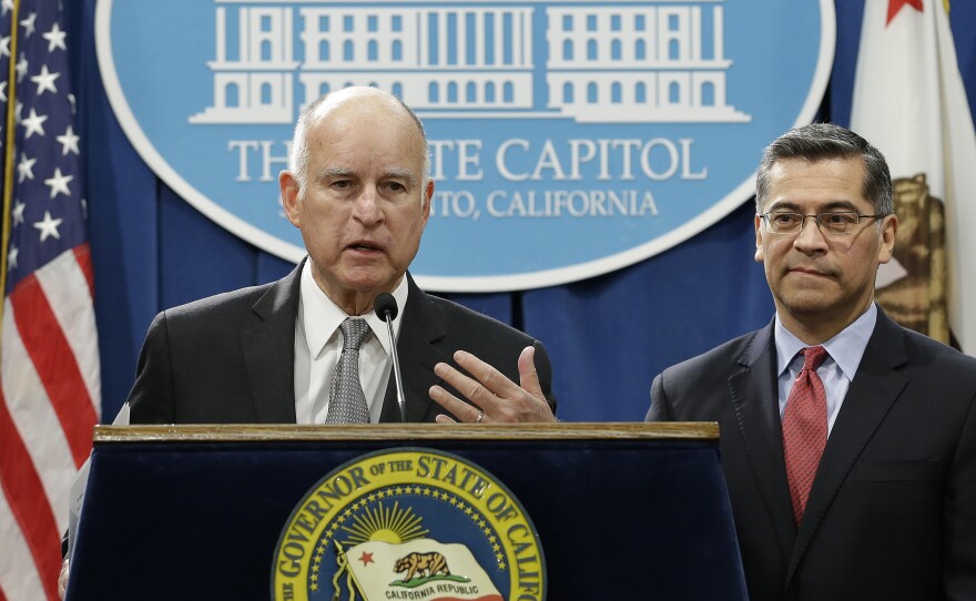 California Gov. Jerry Brown, left, accompanied by California Attorney General Xavier Becerra, listens to a question concerning remarks made U.S. Attorney General Jeff Sessions, Wednesday, March 7, 2018