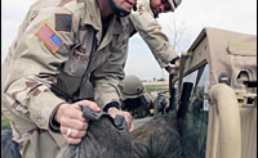 In this 2004 photo, U.S. Army Lt. Katrina Metcalfe places sandbags on a vehicle for protection in the event of an attack by gunfire at a palace of ousted Iraqi president Saddam Hussein in Tikrit, Iraq.