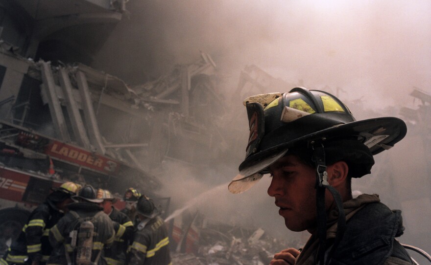 Firemen work to put out the burning fire in the rubble following the collapse of the World Trade Center.