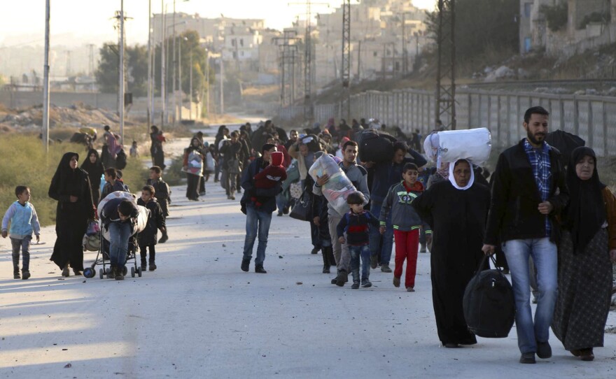 People flee rebel-held eastern neighborhoods of Aleppo into the Sheikh Maqsud area, controlled by Kurdish fighters, in Syria on Sunday. The photo was provided by the Rumaf, a Syrian Kurdish activist group, and authenticated by The Associated Press.