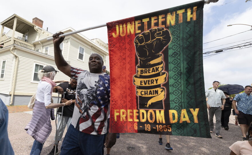 Robert Reid holds a flag during a Juneteenth celebration at the African Burying Ground Memorial Park Thursday, June 19, 2025, in Portsmouth, N.H.