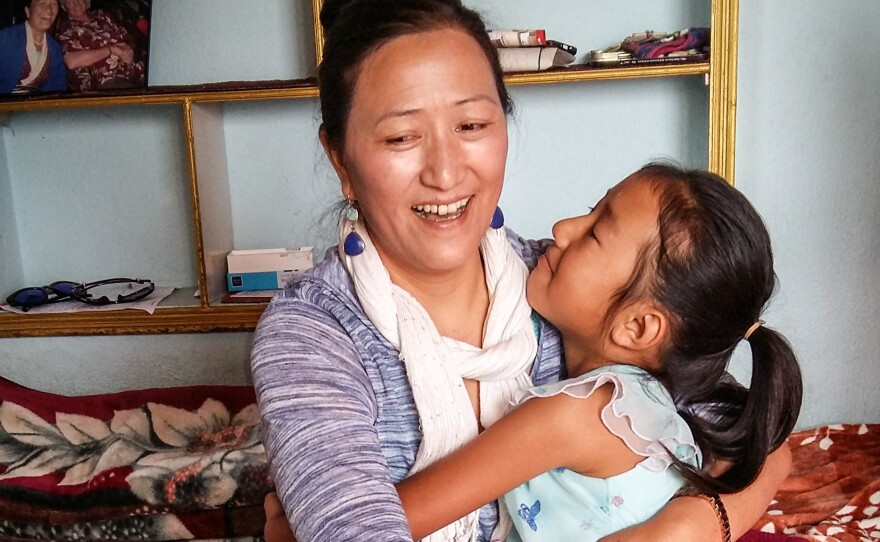 Chheten Drolma and her niece embrace. Drolma's sister — the little girl's mother — died in the disaster. Drolma is now in the process of adopting her late sister's three daughters.