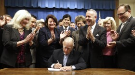 Gov. Jerry Brown receives applause from lawmakers as he signs a measure to place a $7.5 billion water plan on the November ballot in Sacramento, August 13, 2014.