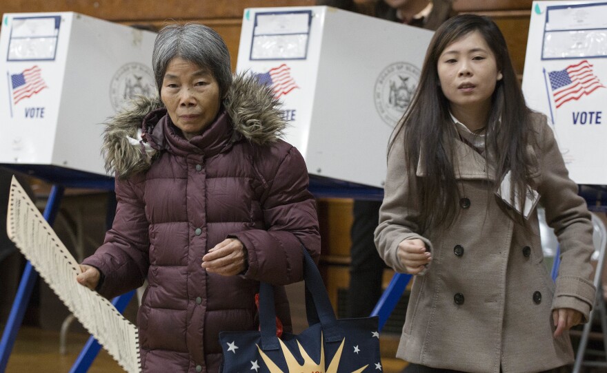 Ping Chan (right), a Chinese-language interpreter, assists a voter in Brooklyn, N.Y., on Nov. 8, 2016.