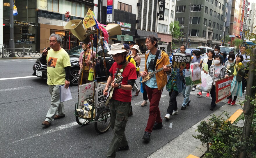 Roughly 250 Japanese demonstrators take part in a march through downtown Tokyo on Saturday, protesting Prime Minister Shinzo Abe's policies on strengthening Japan's national defense.