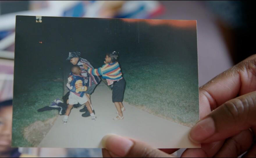 Reneasha Jacobs, James' older sister, holds an old photograph of herself and her two brothers from when they were kids. James shot and killed someone on April 16, 2004. Three days later, their older brother was murdered.