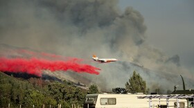 An air tanker drops retardant on a wildfire burning above the Spring Lakes community on Sunday, June 24, 2018. 