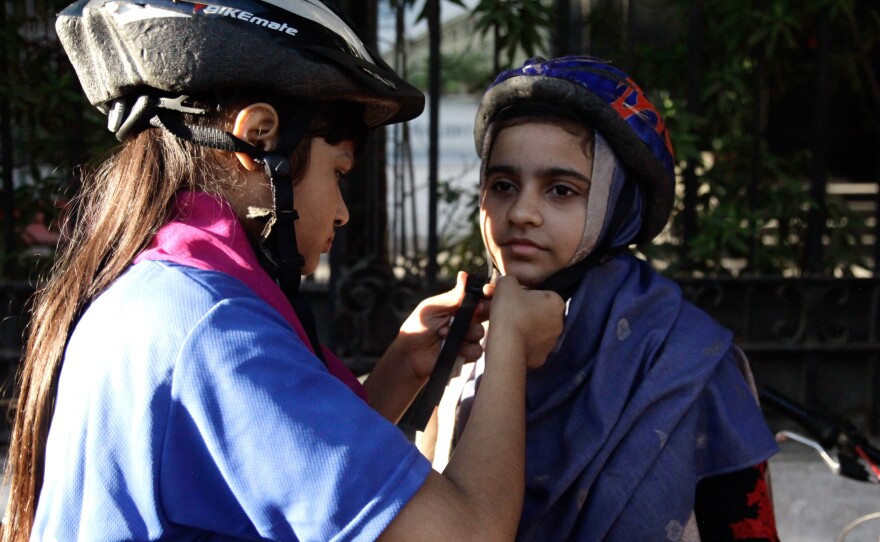 Members of the women's bike group don helmets before their ride.