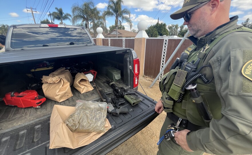 Riverside County Sheriff Department Sergeant Jeremy Parsons collects cannabis clippings and firearms from an unlicensed greenhouse in Perris, CA.