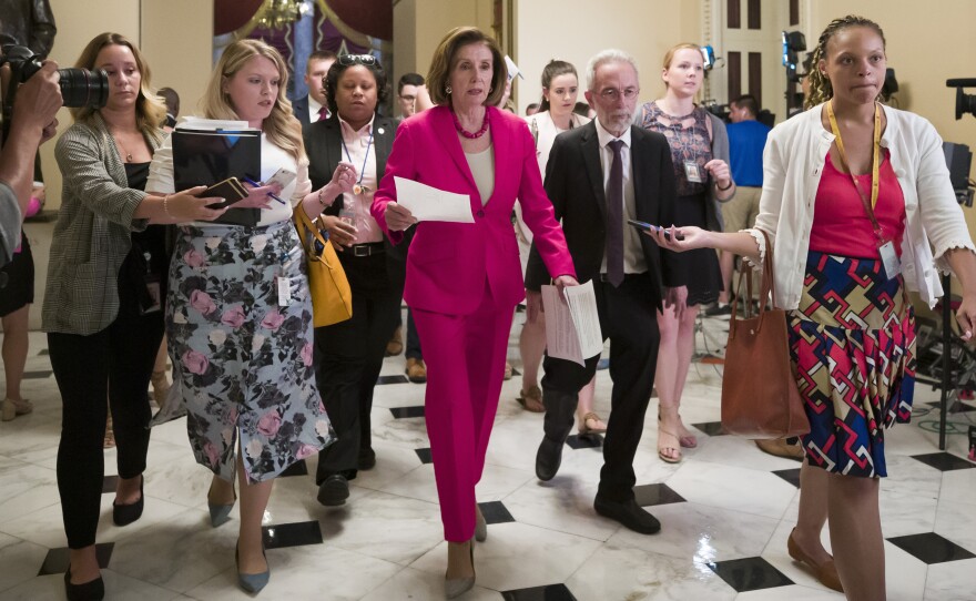 Speaker Nancy Pelosi of California walks to the House floor Thursday. In a letter to Democratic lawmakers she announced the House would "reluctantly" pass a Senate version of an emergency immigration aid package.