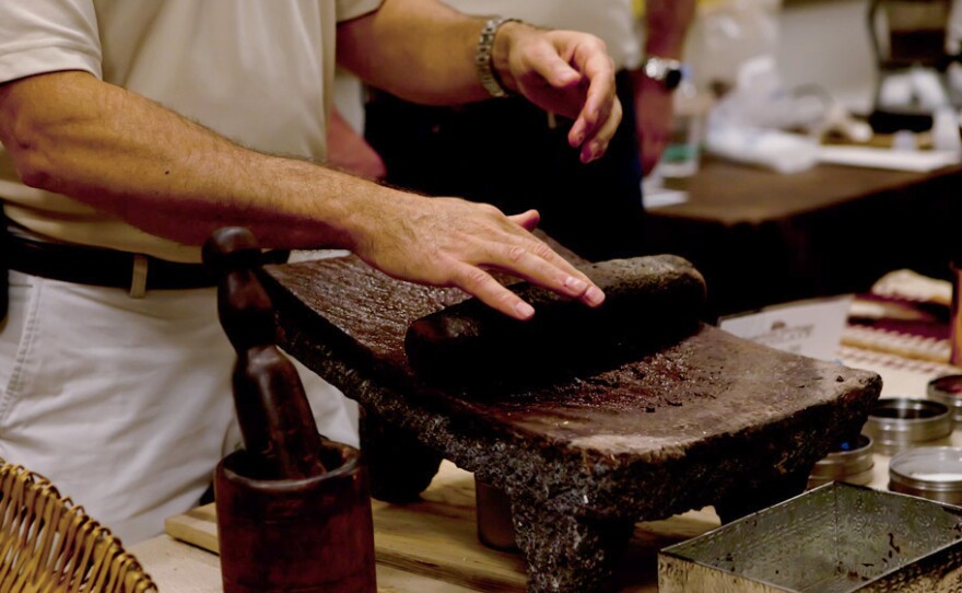 A Mars Inc. employee demonstrates how cacao beans are ground into cocoa powder at a chocolate-making demonstration at the National Archives.