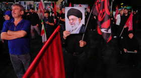 A man holds a poster of the late Iranian Supreme Leader Ayatollah Ali Khamenei in a gathering commemorating him at a square in Tehran, Saturday, July 11, 2026.