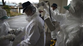 Japanese policemen wearing a protective suits undergo testing for possible nuclear radiation at screening center about 35 kilometers away from Fukushima Nuclear Power Plant as they finish their duty inside exclusion zone on April 9, 2011 in Minamisoma, Fukushima Prefecture, Japan. 