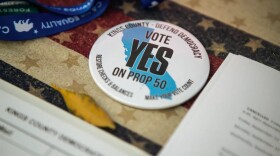 A button reads, “Vote Yes on Prop 50” at the Kings County Democrats booth during the Thursday Night Marketplace in downtown Hanford on Sept. 25, 2025. 