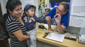 Pediatrician Charles Goodman, talks with patient Carmen Lopez, 37, holding her 18-month-old son, Daniel after being vaccinated with the measles-mumps-rubella vaccine, or MMR at his practice in Northridge, Calif., Thursday, Jan. 29, 2015.