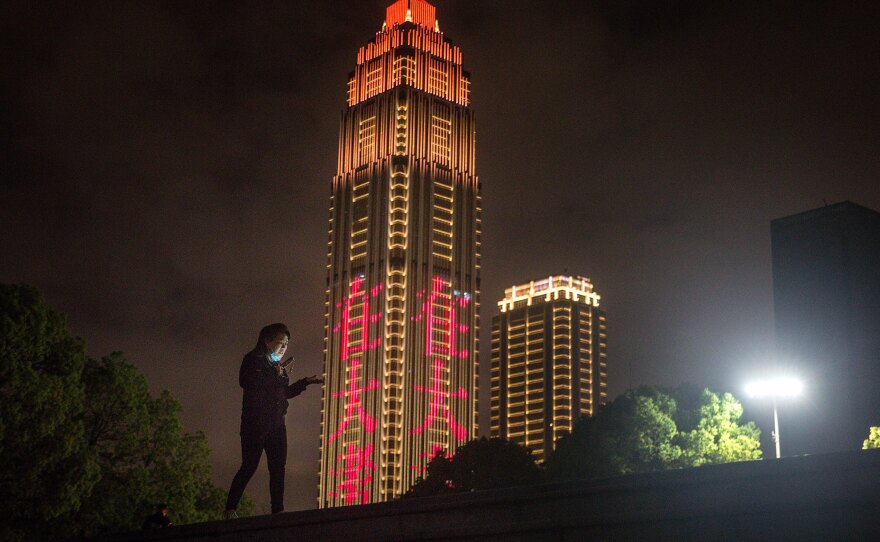 A resident talks on the phone while walking in Jiangtan park after its reopening in March in Wuhan, Hubei province, China. The new coronavirus pandemic felt thousands of miles away, until it didn't. As cases in the U.S. skyrocketed, many noticed a shift — from watching the headlines, to watching what we touch.