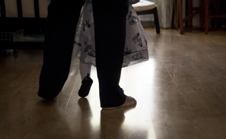 Wanda holds Soleil's hands as she learns to walk.