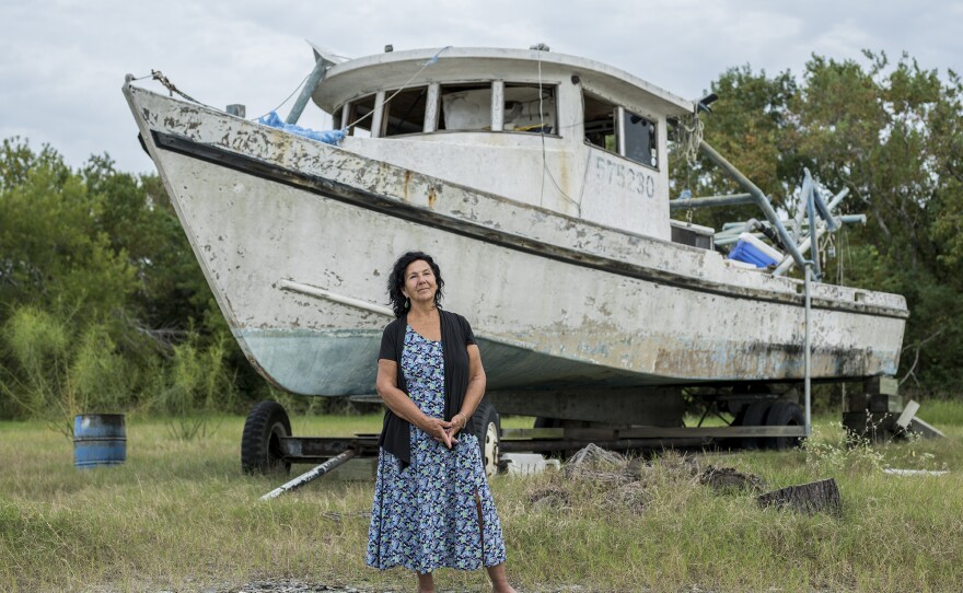 Diane Wilson, an outspoken native of Seadrift and a fourth-generation fisherwoman, stands by a retired shrimp boat.