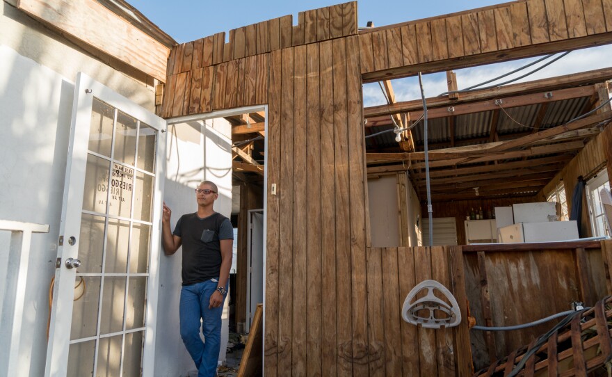 Angel Joel Alvarez Lopez stands by the door of his wood house above his mother's cement house in the Bayamon municipality outside San Juan, Puerto Rico, which was destroyed by Hurricane Maria. He built this wood-and-tin second floor addition about 15 years ago.