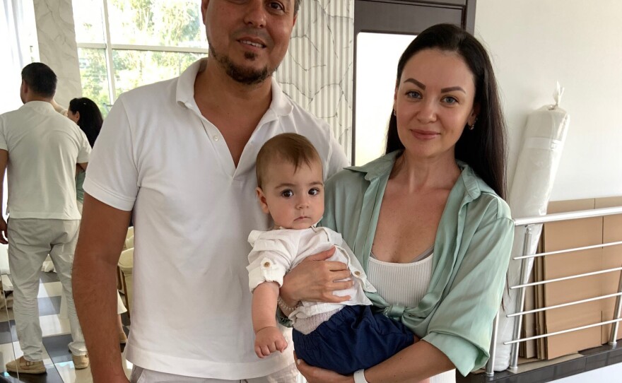Wedding dress designer Yana Bashmakova, holding son Adam, runs the Ukrainian wedding dress company Giovanna Alessandro along with her husband Alexandr Marandyuk.